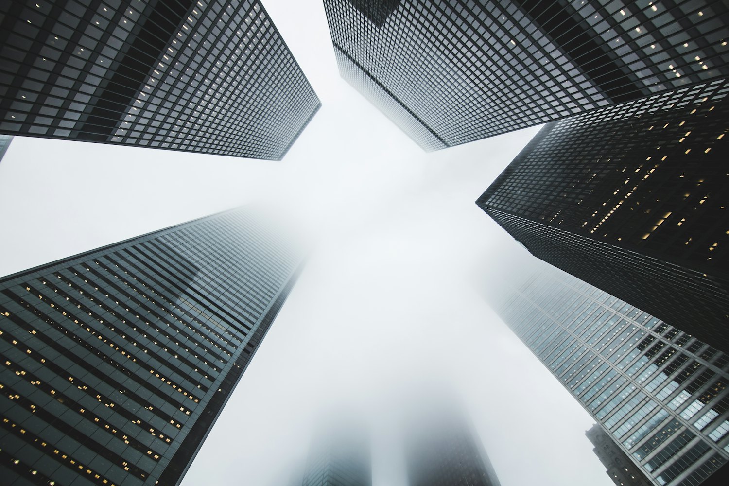 Civic-scale towers rising into cool daylight, seen from below.