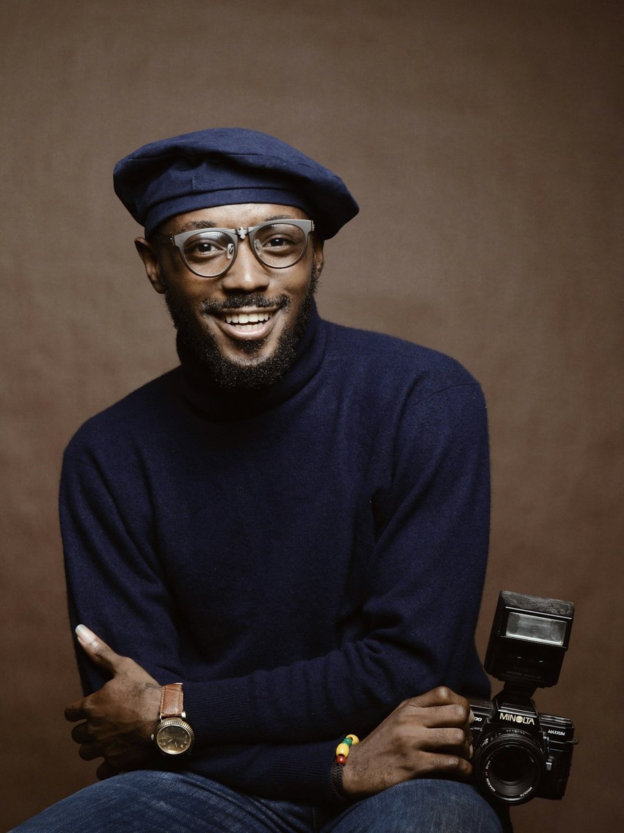 A man holding a camera, smiling.