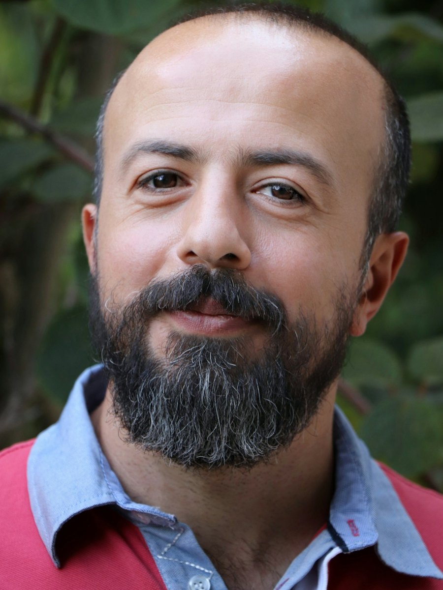 A bearded man looking toward the camera with a calm expression.