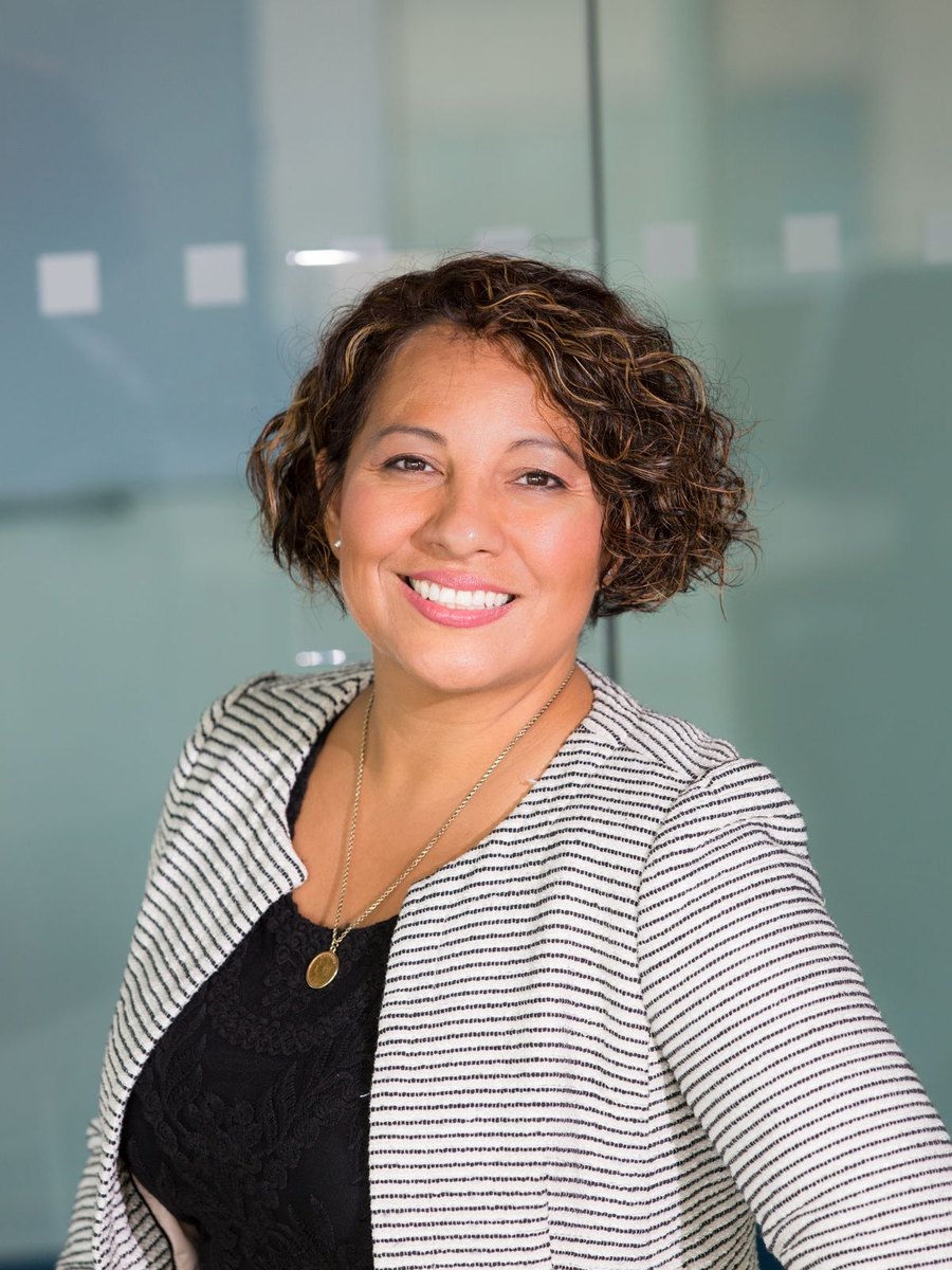 A woman in a striped blazer smiling.