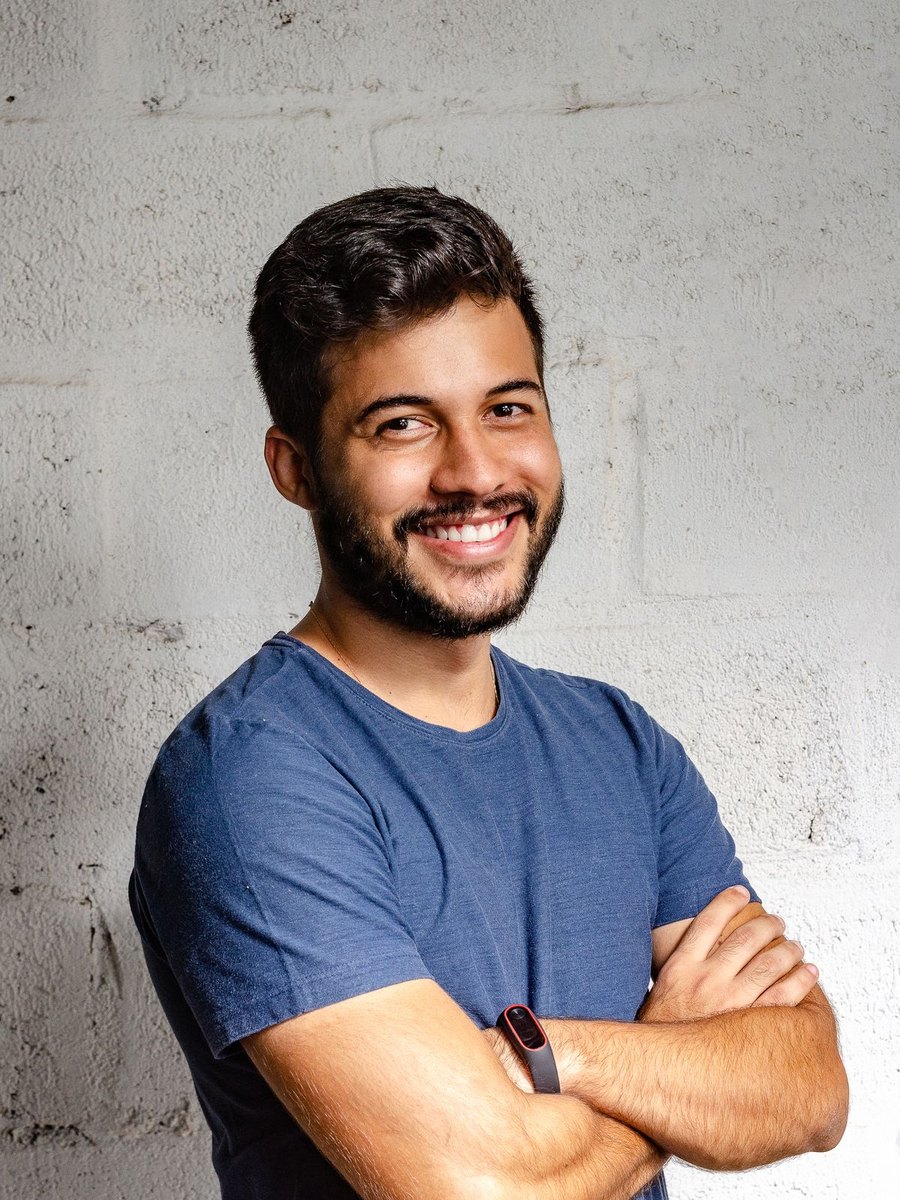 A man smiling with his arms crossed.