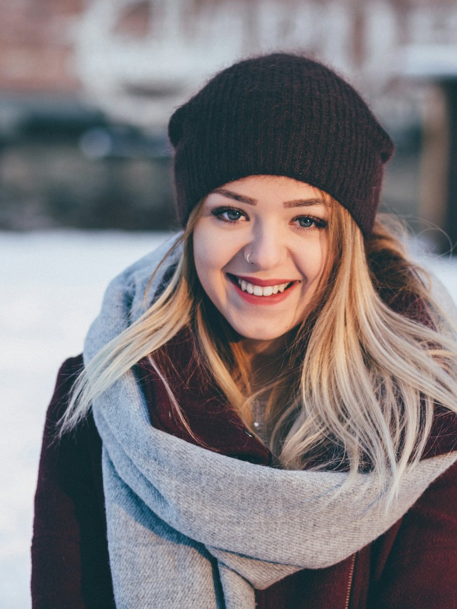 A woman in winter clothes smiling outdoors.