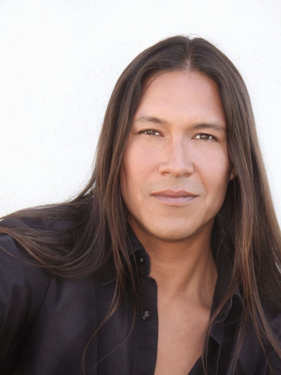 A man in a black shirt looking toward the camera.