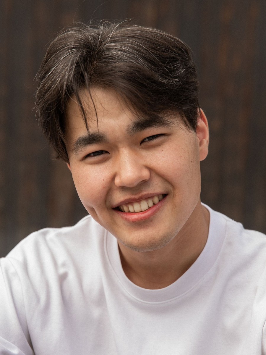 A man in a white shirt smiling toward the camera.
