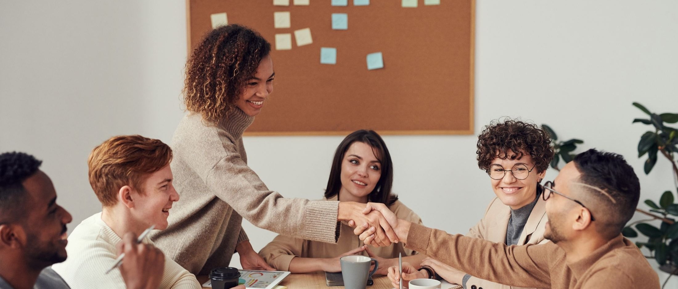 People gathered around a table, meeting as people first: one address that means a person.